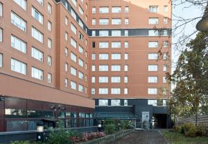 un grand bâtiment avec une passerelle devant lui dans l'établissement B&B HOTEL Paris Nord 18ème, à Paris