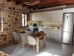 a kitchen with a table with chairs and a refrigerator at Kagiampakis Concept Residences in Avdou