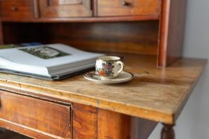 a coffee cup and a book on a wooden table at Stylish Studio for 2 with Balcony Robocza Poznań by Renters in Poznań