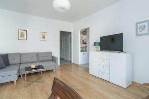 a living room with a couch and a tv at Stylish Studio for 2 with Balcony Robocza Poznań by Renters in Poznań