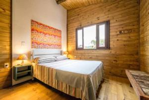 een slaapkamer met een bed in een houten muur bij Casa do Cumbata in Palhoça