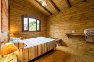 een slaapkamer met houten wanden en een bed in een kamer bij Casa do Cumbata in Palhoça