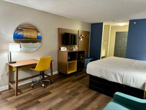 a hotel room with a bed and a desk and chair at Days Inn by Wyndham Sarasota I-75 in Sarasota