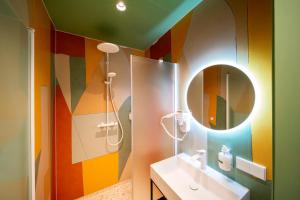 a colorful bathroom with a sink and a mirror at Budget Hotel Tourist Inn in Amsterdam