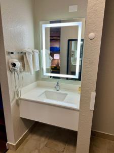 een badkamer met een wastafel en een spiegel bij Days Inn by Wyndham Sarasota I-75 in Sarasota