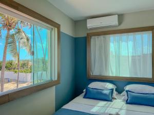 a bedroom with a bed and a window with a palm tree at Isla Beach Hotel in Pecém