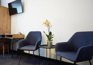 two blue chairs and a table with a vase of flowers at Włodary Tennis Junior in Częstochowa