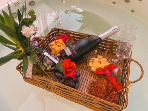 a basket with a bottle of wine and flowers at Maruê Guesthouse Porto de Pedras in Pôrto de Pedras