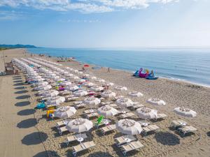 - un grand groupe de parasols et de chaises sur une plage dans l'établissement 4 Mori Family Village - Villaggio per Famiglie, à Muravera