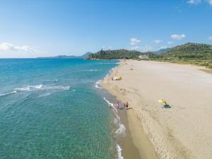 grupa ludzi na plaży z oceanem w obiekcie 4 Mori Family Village - Villaggio per Famiglie w mieście Muravera