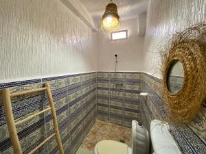 y baño con aseo y espejo. en Red Carpet Surf Camp, en Tamraght Ouzdar