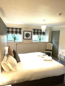 a large white bed in a room with windows at Slyne Lodge in Hest Bank