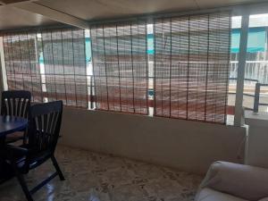 een kamer met grote ramen met een tafel en stoelen bij Atico Centro in Benidorm