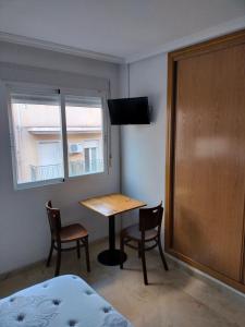 una camera con tavolo, sedie e finestra di Piccadilly Centre Deluxe ad Alicante