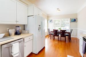 uma cozinha com armários brancos e uma mesa com cadeiras em Goshen Getaway em Augusta