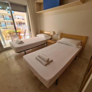 2 Betten in einem Zimmer mit Fenster in der Unterkunft Apartamento Alcotan I Beach in Cala de Finestrat