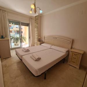 ein Schlafzimmer mit einem Bett mit zwei Handtüchern darauf in der Unterkunft Apartamento Alcotan I Beach in Cala de Finestrat