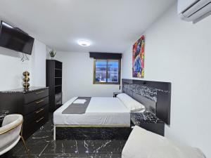 sypialnia z łóżkiem, umywalką i telewizorem w obiekcie Apartamentos Benidorm Black w mieście Benidorm