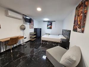 Pokój z łóżkiem, biurkiem i kanapą w obiekcie Apartamentos Benidorm Black w mieście Benidorm