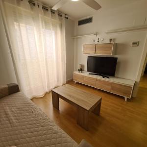 a living room with a flat screen tv and a coffee table at Apartamento Cruzamar IF Beach in Benidorm