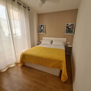 a bedroom with a bed with a yellow blanket at Apartamento Cruzamar IF Beach in Benidorm +34 photos
