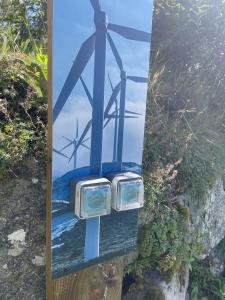 a painting of two wind turbines on a sign at La Ferme de Jean entre lacs et montagnes in Saulxures-sur-Moselotte