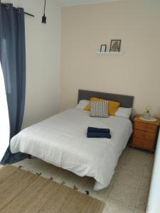 een slaapkamer met een wit bed met gele en blauwe kussens bij La Casita de Puerto in Puerto del Rosario