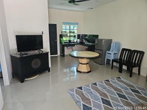 a living room with a tv and a table and chairs at MRI Residence - Homestay in Sg Buloh with Swimming Pool - No Pork&Alcohol Allowed in Bandar Puncak Alam