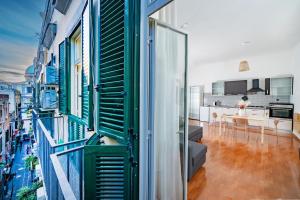 um quarto com janelas verdes e brancas e uma cozinha em Casa Blin Dimora a Chiaia em Nápoles