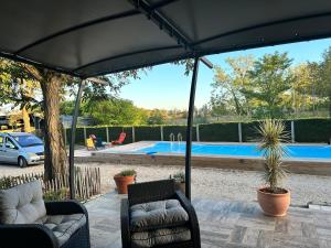 a patio with two chairs and a swimming pool at Chambre chez Alain et Armelle in Avoine