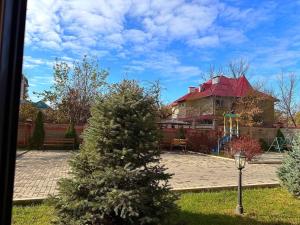a christmas tree in front of a house with a playground at Stay Hostel in Bishkek