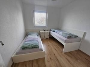 Duas camas num pequeno quarto com pisos em madeira em Wohnung in Gunskirchen / Wels em Gunskirchen