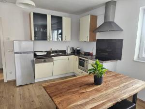 uma cozinha com uma mesa de madeira e um frigorífico em Wohnung in Gunskirchen / Wels em Gunskirchen