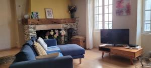een woonkamer met een blauwe bank en een televisie bij Catalan Cottage terrace and secure garage in Rigarda