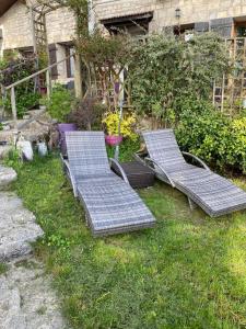 two empty benches sitting in the grass in a yard at Aux Lacs et Cascades in Songeson