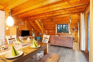 uma sala de estar em cabana de madeira com uma mesa e um sofá em Mühlenblick em Medebach