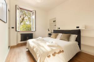 1 dormitorio blanco con 1 cama grande y 2 toallas en HL Apartment - Darsena, Navigli Milano, Via Torino, en Milán