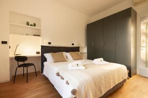 1 dormitorio con 1 cama grande y 2 toallas. en HL Apartment - Darsena, Navigli Milano, Via Torino, en Milán