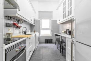 a kitchen with white cabinets and a counter top at Apart T3 com piscina tenis ginasio e parq infant in Lisbon