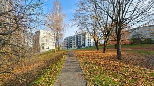 um caminho num parque com árvores e edifícios em Kavoliuko 14 em Vilnius