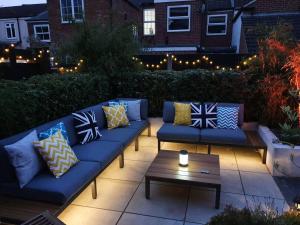 a patio with blue couches and a table and lights at Cozy Double Room with Parking and Full Kitchen in Southampton