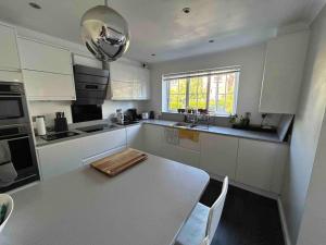 a kitchen with white cabinets and a table with chairs at Cozy Double Room with Parking and Full Kitchen in Southampton