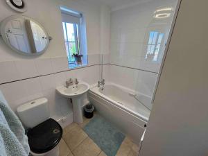 a white bathroom with a sink and a tub and a toilet at Cozy Double Room with Parking and Full Kitchen in Southampton
