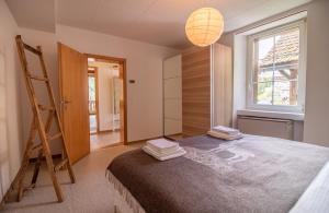 1 dormitorio con cama, escalera y ventana en Weisshorn Apartment by Arosa Holiday, en Arosa