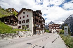 an empty road in a mountain village with buildings at Weisshorn Apartment by Arosa Holiday in Arosa