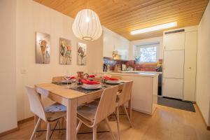 cocina y comedor con mesa de madera y sillas en Weisshorn Apartment by Arosa Holiday, en Arosa