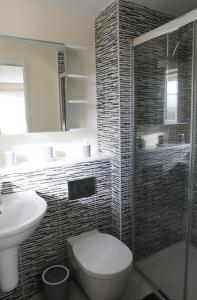 a bathroom with a toilet and a sink and a shower at Spacious home with office and double driveway & FREE Wifi By ULTIMATE HOMES AWAY in Winnersh +42 photos