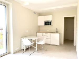a white kitchen with two chairs and a table at Appartamento tranquillo vicino ad Alba in Mussotto