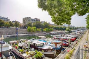 a bunch of boats docked in a river at Charming Apart NEW 2 Bedrooms with Aircon in Paris