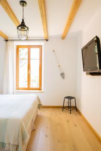 ein Schlafzimmer mit einem Bett und einem TV an der Wand in der Unterkunft Des sapins aux étoiles in Pierre-Percée
